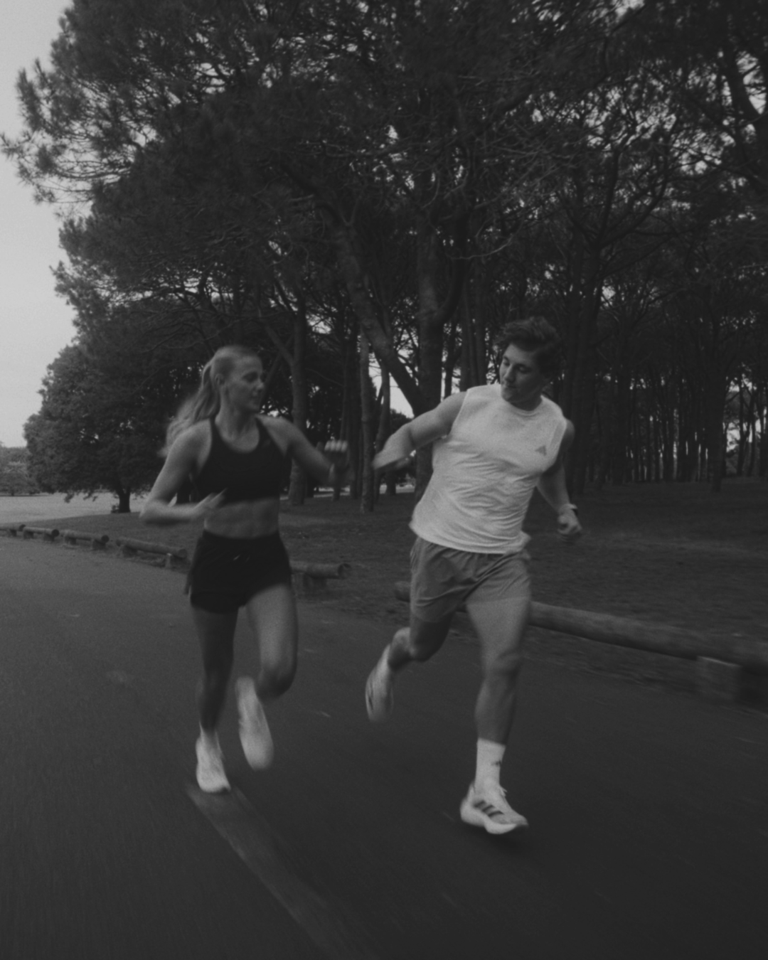 HIIT athletes running together at dusk, black and white