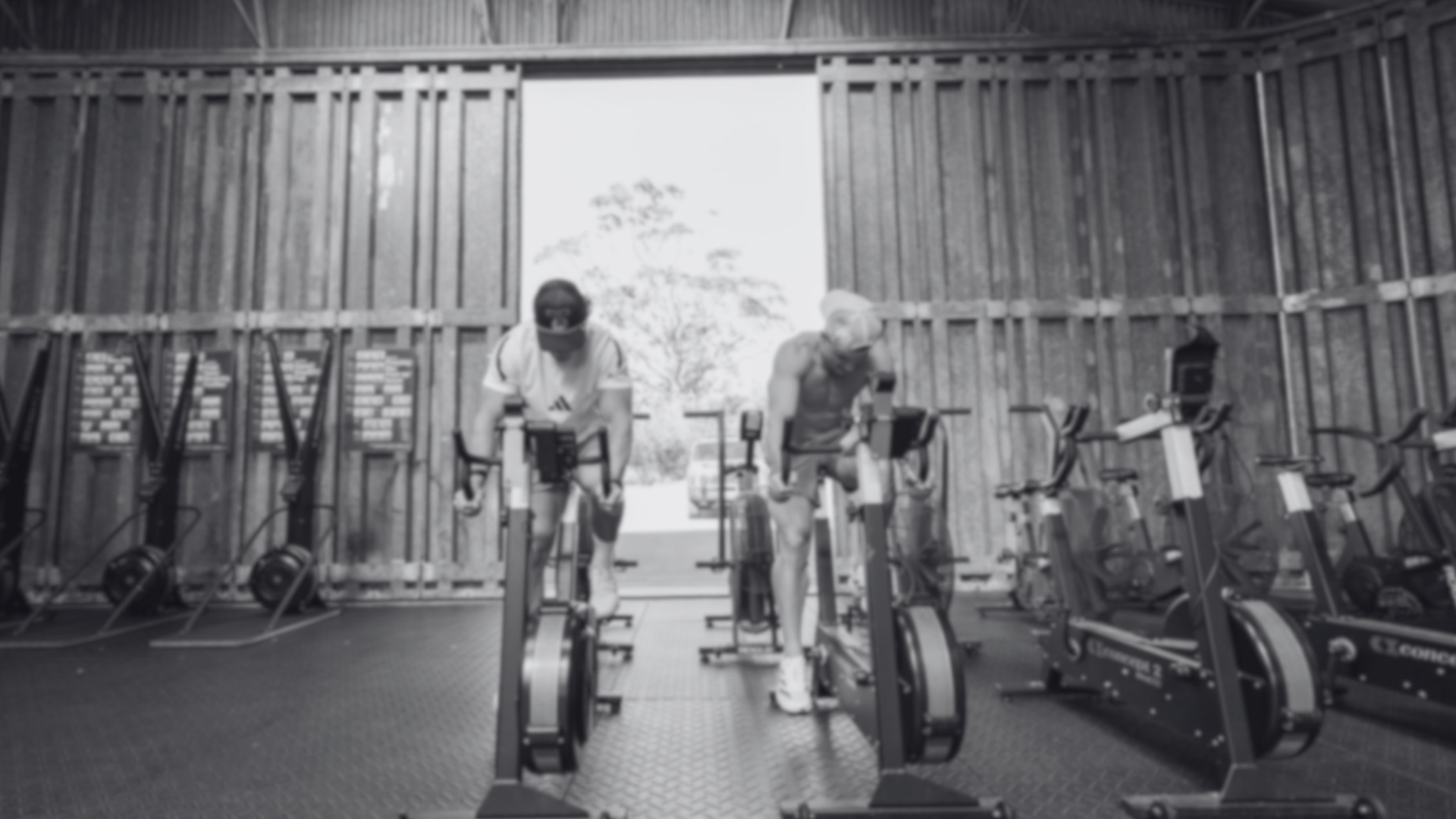 HIIT athletes training on rowers, black and white
